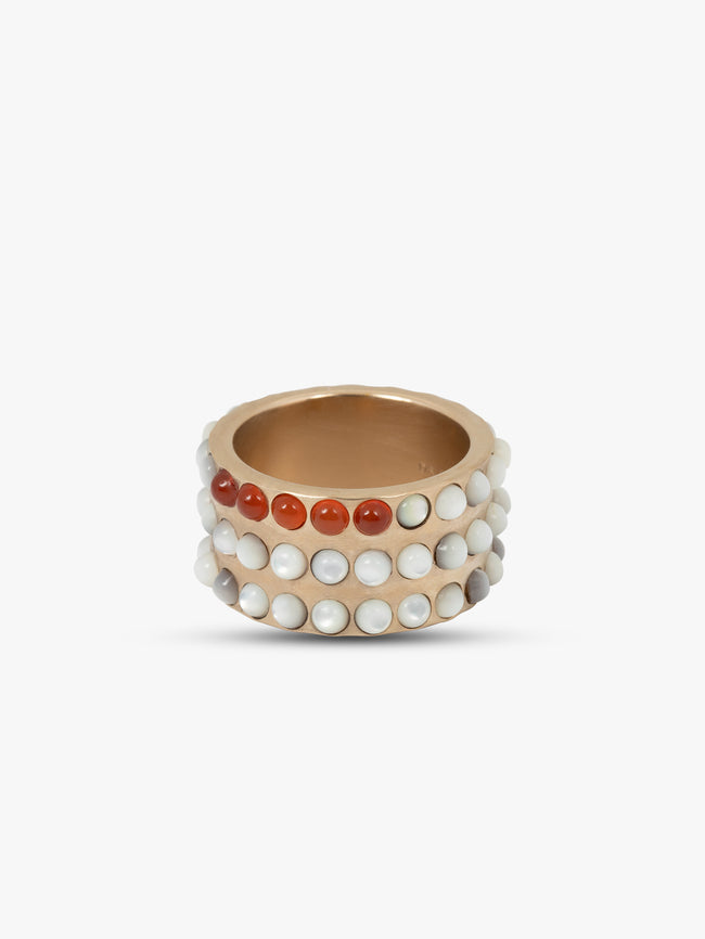 Gold ring with red and white bead accents on a white background