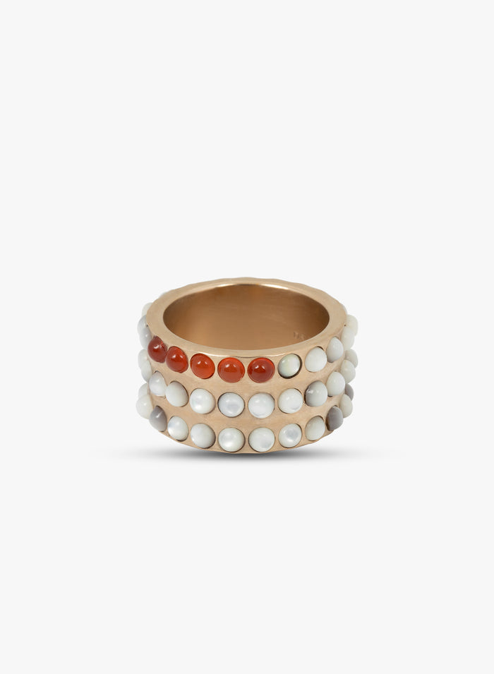 Gold ring with red and white bead accents on a white background