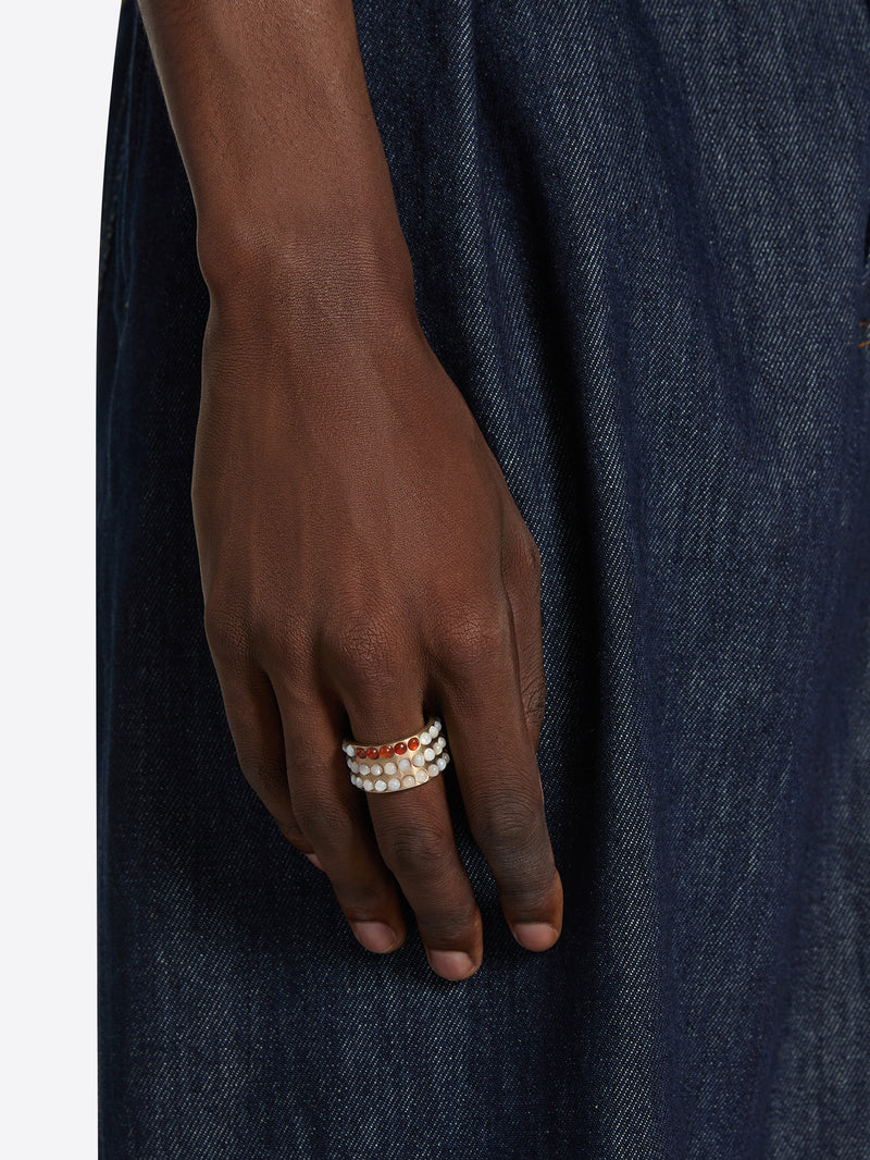 Hand wearing a ring on a dark denim background