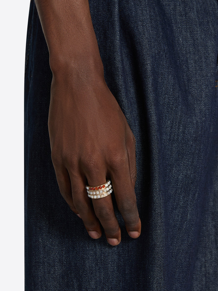 Hand wearing a ring on a dark denim background