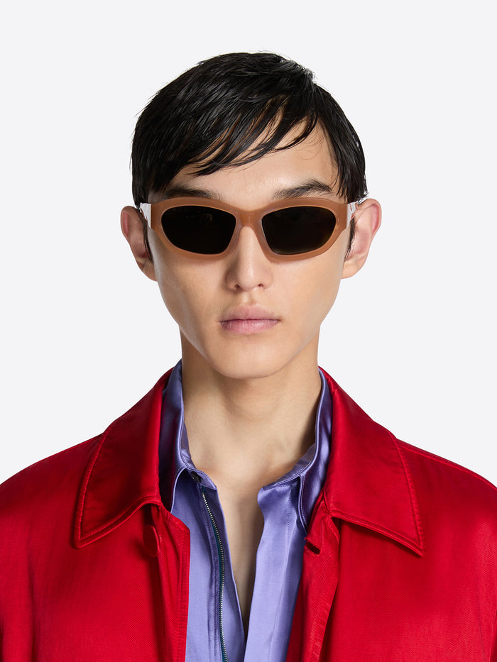 Person wearing sunglasses and a red jacket on a white background