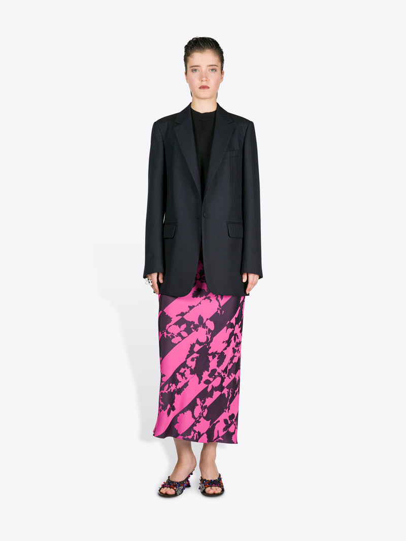 Woman wearing a black blazer and pink and black patterned skirt on a white background - Dries Van Noten