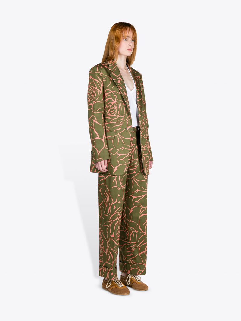 Person wearing a green patterned suit on a white background