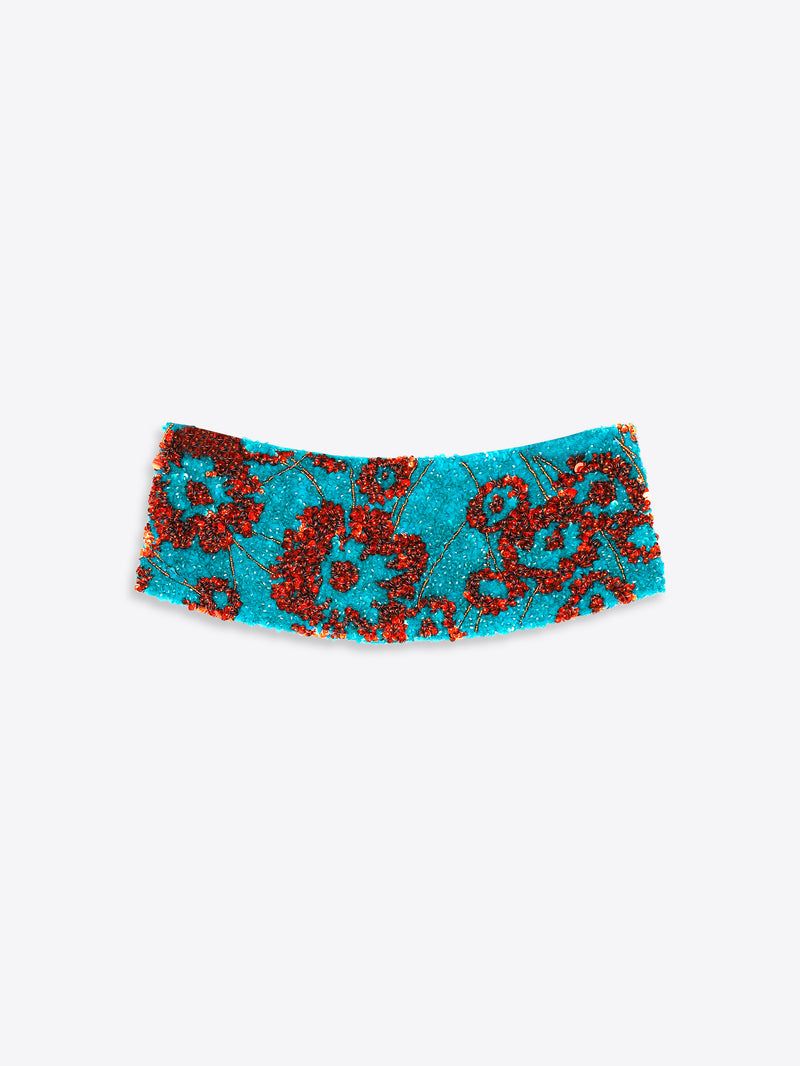 Turquoise cummerbund with red pattern on a white background