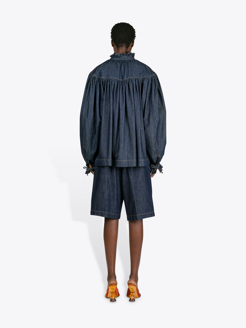 Person wearing a denim outfit with a white background