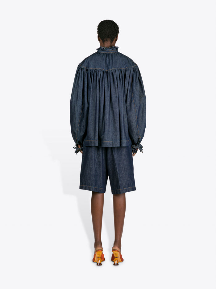 Person wearing a denim outfit with a white background