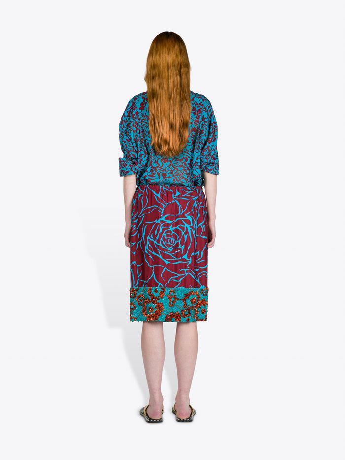 Person wearing a colorful patterned outfit on a white background