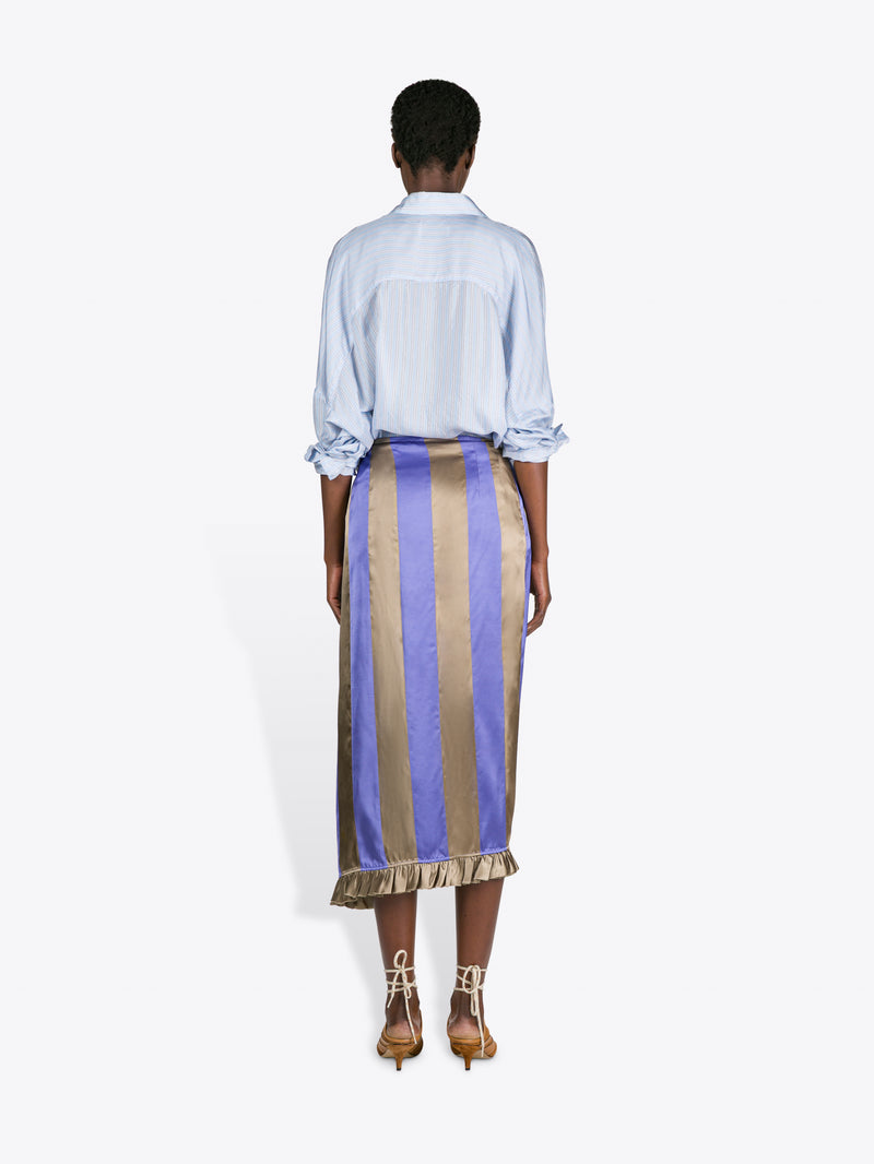 Person wearing a light blue shirt and striped skirt on a white background