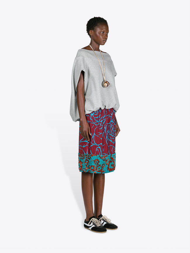Woman wearing a white top and colorful skirt on a white background - Dries Van Noten