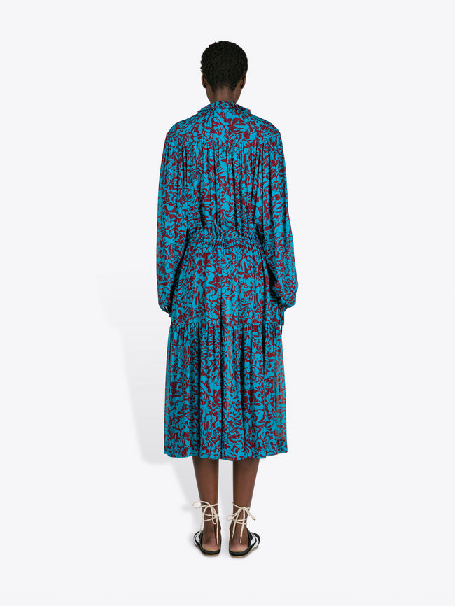 Person wearing a blue floral dress on a white background