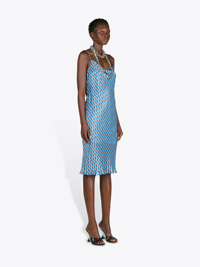 Woman wearing a blue patterned dress on a white background