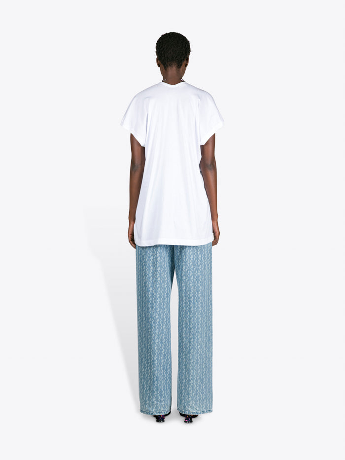 Person wearing a white t-shirt and blue patterned pants on a white background