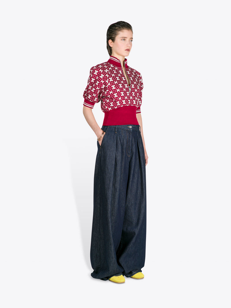 Woman wearing a red and white patterned top with dark blue wide-leg pants on a white background - Dries Van Noten