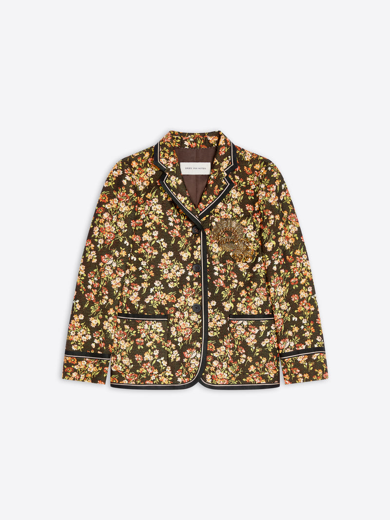 A women's blazer jacket featuring an all-over dense floral print with contrasting black piping along the collar, front, cuffs, and hem.