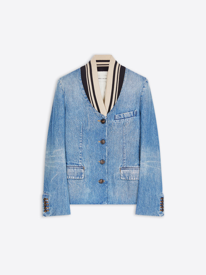 A light blue denim jacket with a striped black, white, and beige shawl collar, featuring front buttons and flap pockets, displayed on a gray background. 