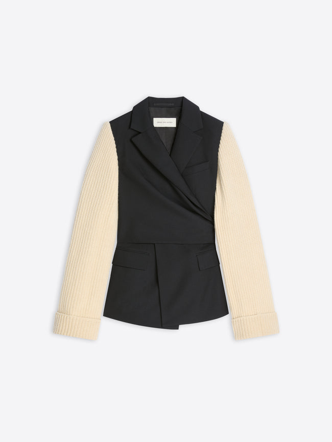 A women's wrap-style blazer with a black body and contrasting cream ribbed knit sleeves, shown flat against a light gray background.