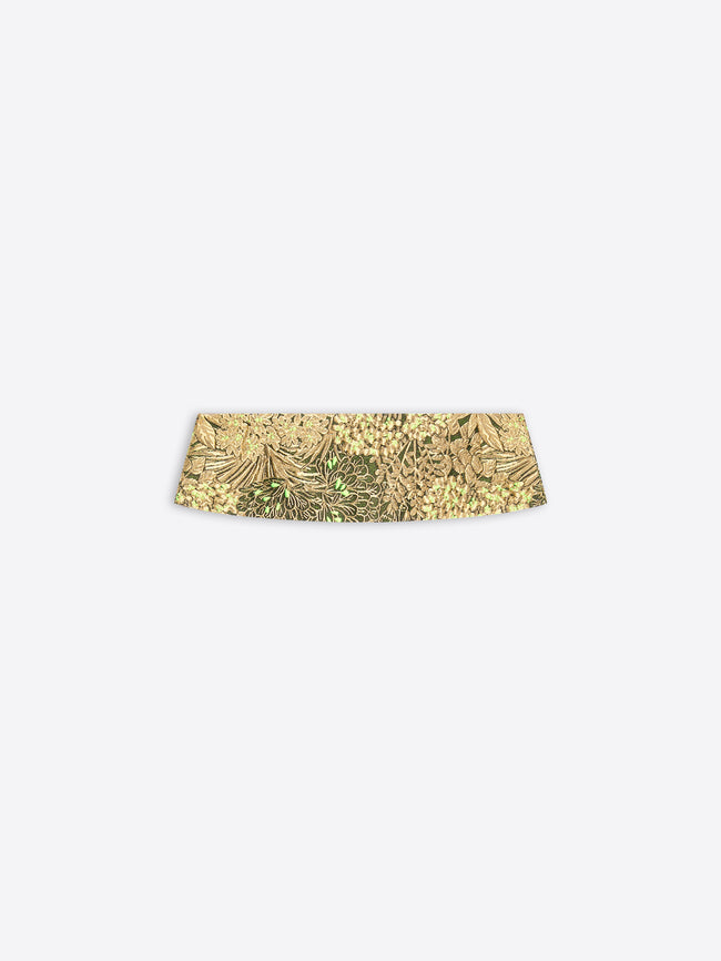 A gold patterned waistband on a light gray background 