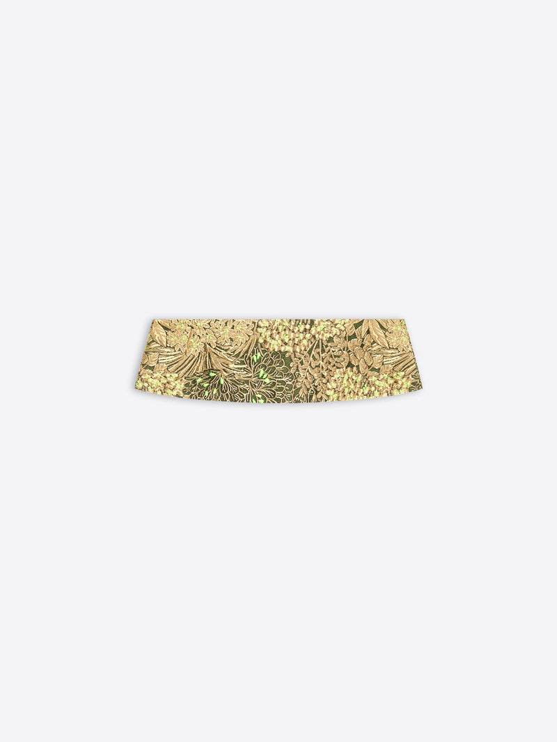 A gold patterned waistband on a light gray background 