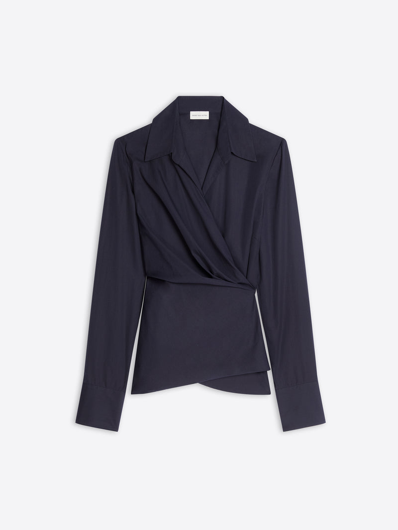 A dark navy wrap-style blazer top with long sleeves, a structured collar, and a draped asymmetrical front, shown on a light gray background.