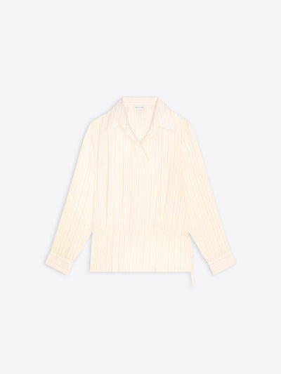 A cream-colored long-sleeve wrap shirt with vertical pleats, shown flat against a light gray background.