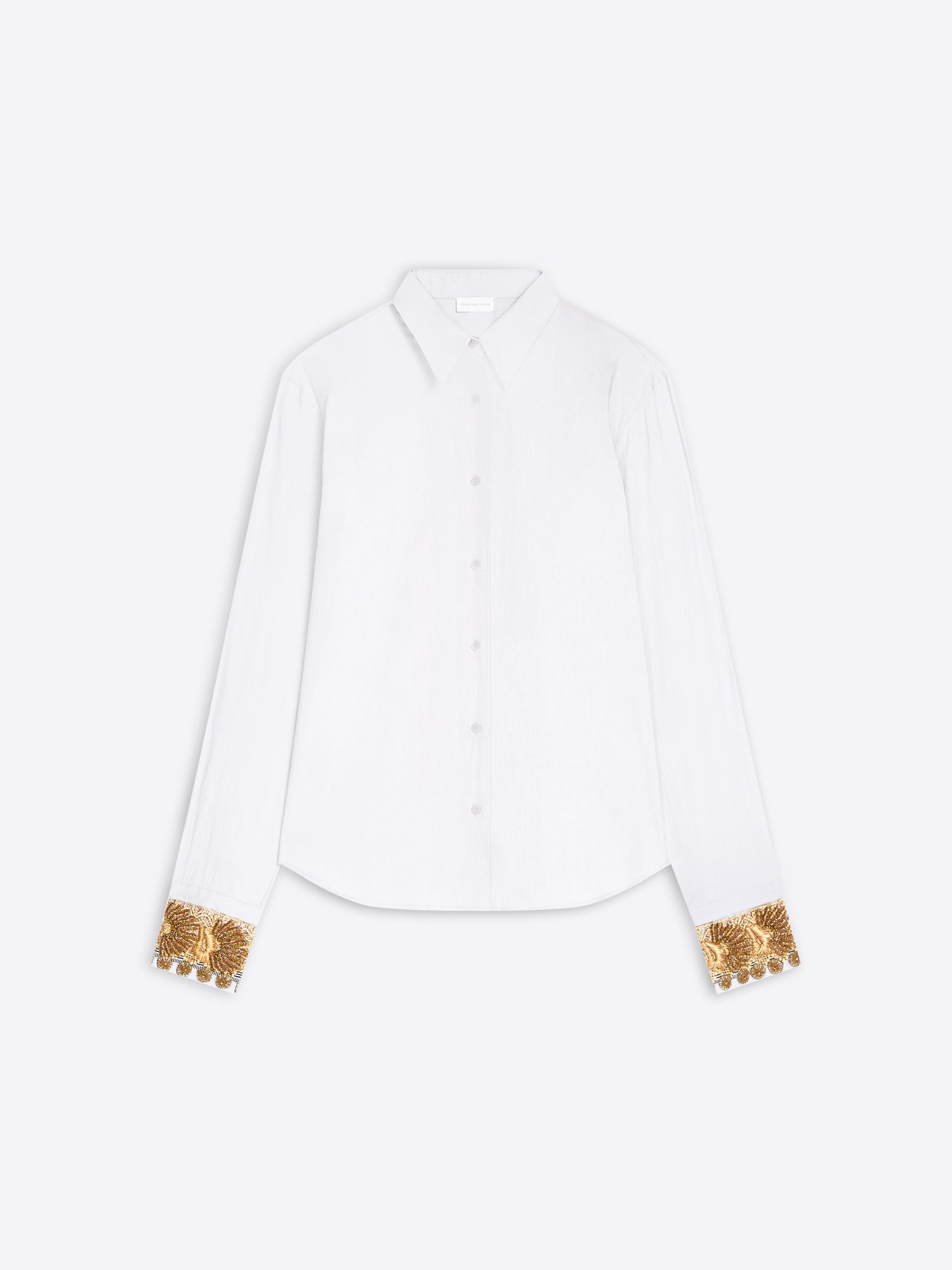 A white long-sleeve button-up shirt with ornate gold sequined cuff details, displayed flat against a light gray background.