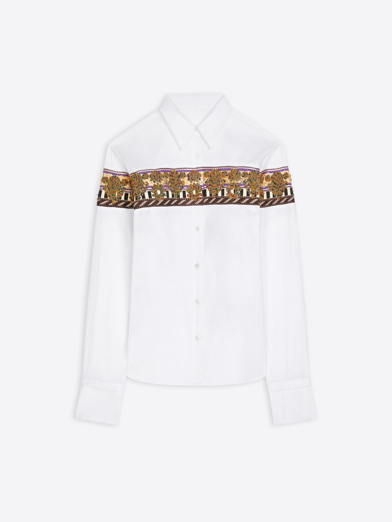 A white long-sleeve shirt with a wide brown patterned band across the chest