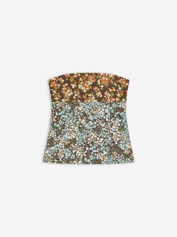 A strapless bandeau top with a split floral pattern, featuring a dark brown top half with orange and cream flowers, and a light blue and cream bottom half, shown on a light gray background.