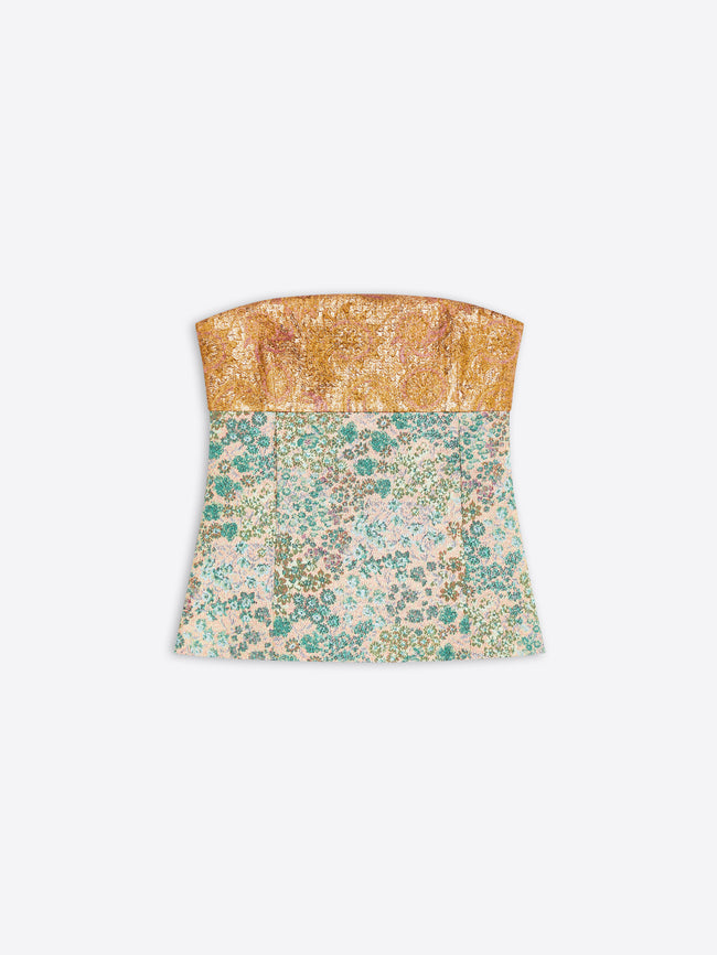 A strapless bandeau top with a textured metallic gold upper band and a flared lower section featuring a floral pattern, shown against a light gray background.