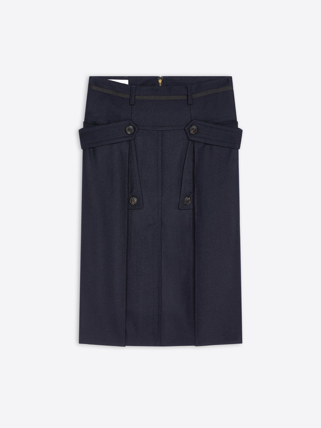 A dark navy blue skirt with structured waist details, buttoned flap pockets, and pleated front panels, shown flat against a light gray background.