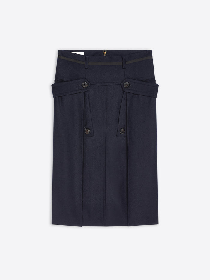 A dark navy blue skirt with structured waist details, buttoned flap pockets, and pleated front panels, shown flat against a light gray background.
