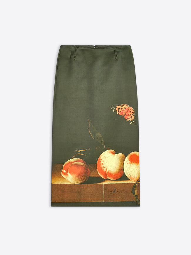 A dark olive green skirt featuring a vintage-style, life print of three peaches on a wooden ledge with a butterfly in the upper right, shown against a light gray background.