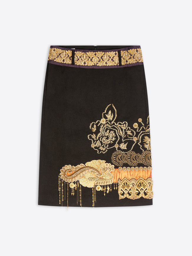 A black midi skirt with ornate gold and orange motifs on a light gray background