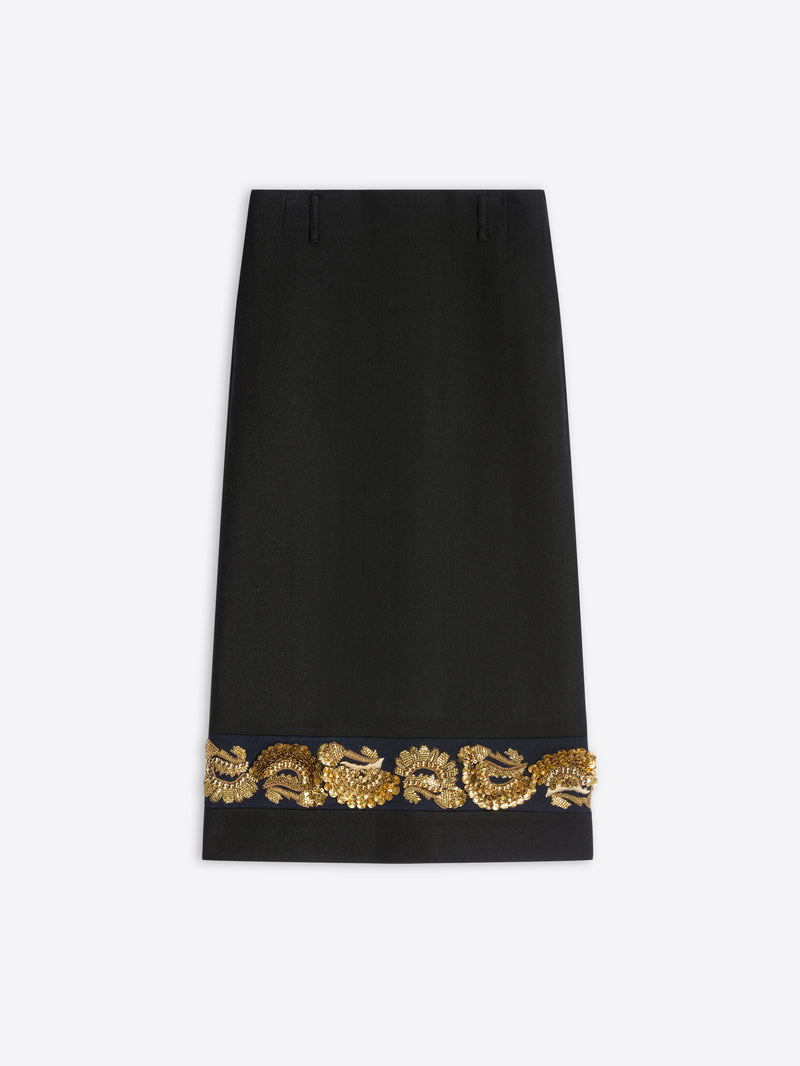 A long black skirt featuring ornate gold embroidery near the hem on a light gray background.