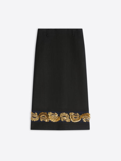 A long black skirt featuring ornate gold embroidery near the hem on a light gray background.
