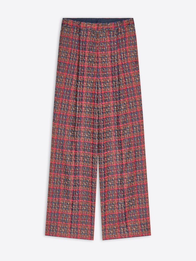 A pair of wide-leg trousers featuring a dense, small-scale multicolor pattern, laid flat against a light gray background.