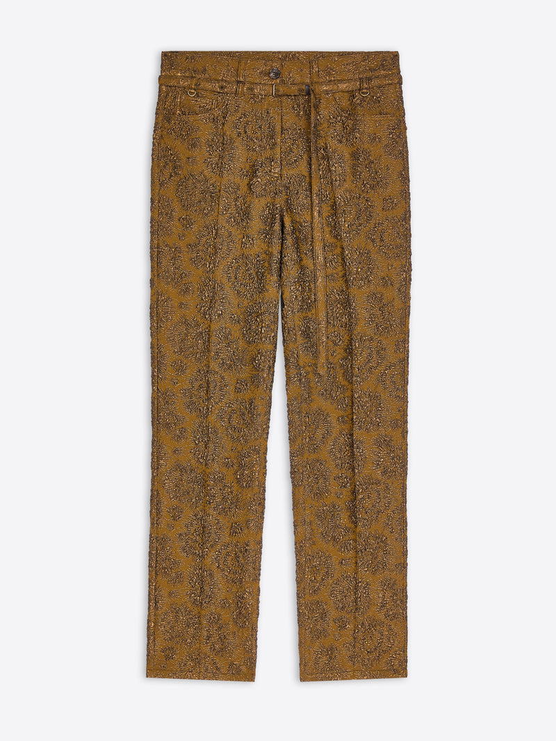 A pair of slim-fit trousers in a textured mustard-brown fabric with an all-over brown paisley pattern, shown flat against a light gray background.