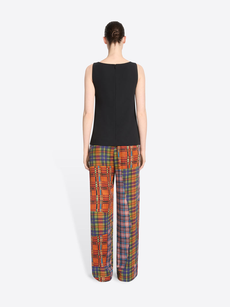 Back view of a model standing against a light gray background wearing a tank top and matching wide-leg plaid pants with vertical patchwork panels.
