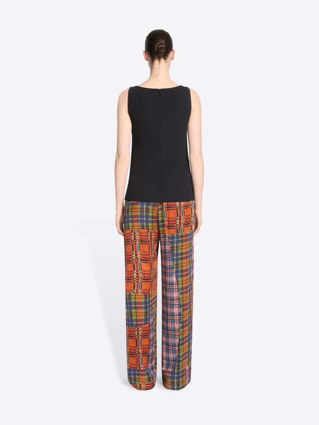 Back view of a model standing against a light gray background wearing a tank top and matching wide-leg plaid pants with vertical patchwork panels.