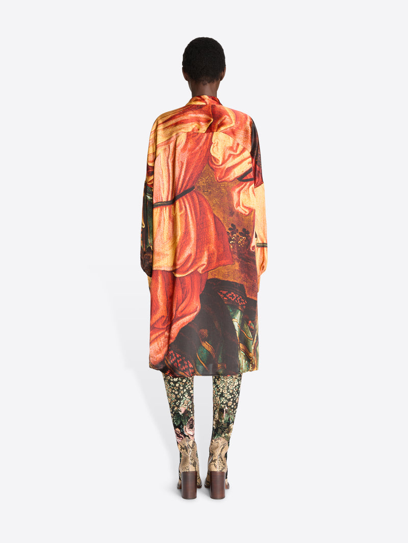 Back view of a model standing against a light gray background wearing a long-sleeve collared shirt dress with an intricate multicolor abstract print , paired with patterned tights and snakeskin heels.