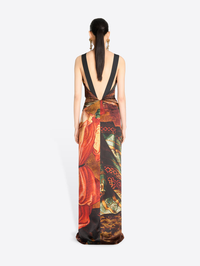 Back view of a model wearing a sleeveless, open-back maxi dress with a rich, multicolored classical painting print set against a light gray background.