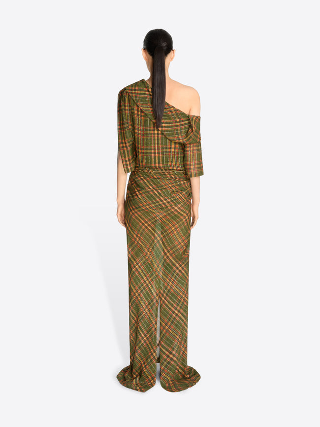 Back view of a model wearing a long, one-shoulder dress with a green and brown plaid pattern and gold tassel detailing at the waist, set against a light gray background.