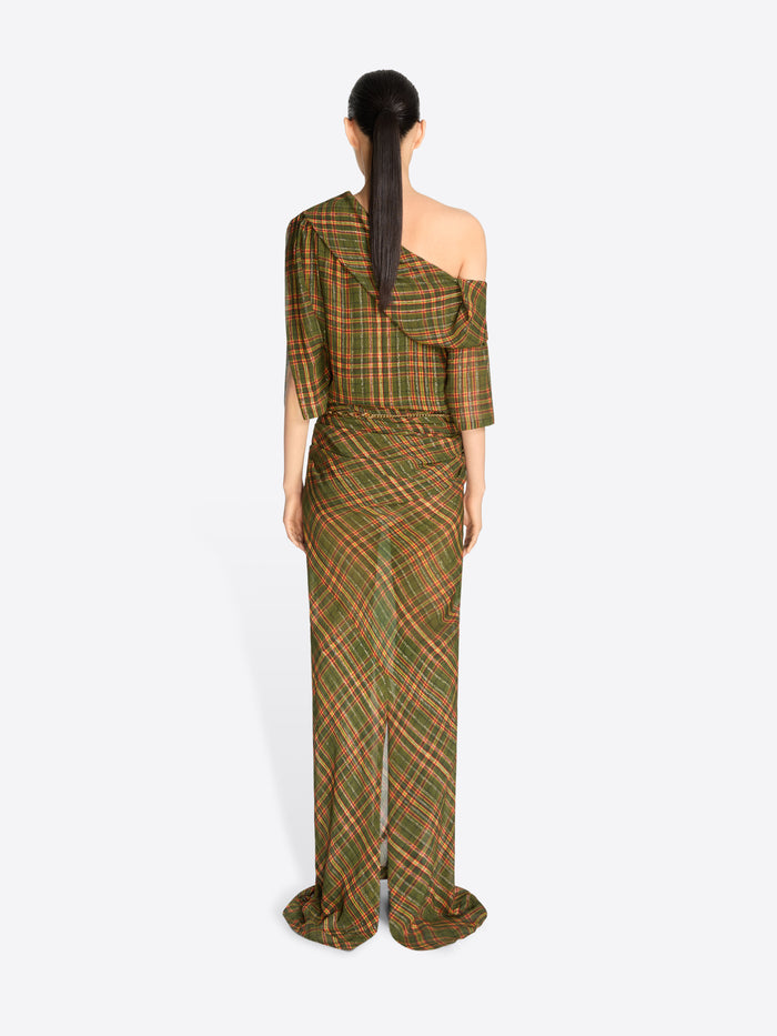 Back view of a model wearing a long, one-shoulder dress with a green and brown plaid pattern and gold tassel detailing at the waist, set against a light gray background.