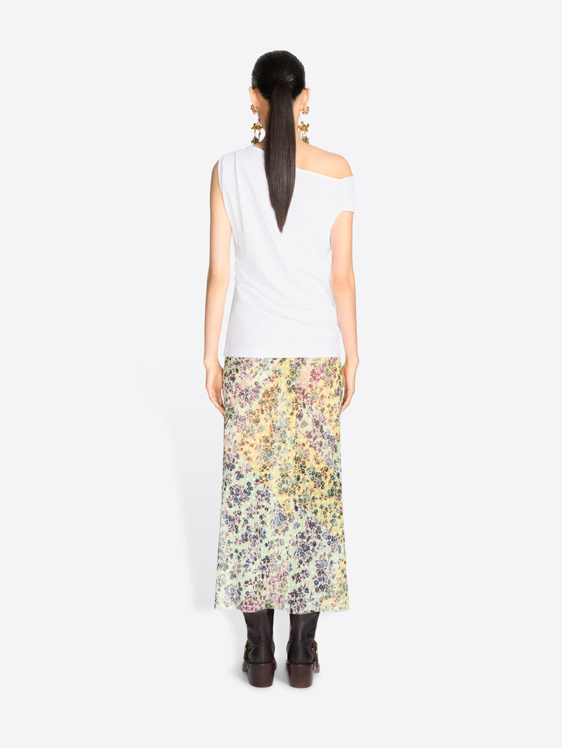 Back view of a model standing against a light gray background wearing a white asymmetrical off-the-shoulder top and a long floral print midi skirt.