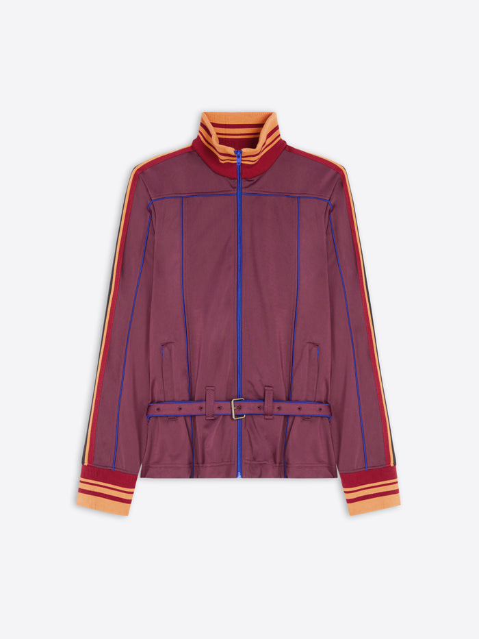 A women's zip-up track jacket in a muted burgundy-purple color, featuring blue piping details, orange and yellow striped accents on the collar, cuffs, and sleeves, and a matching purple belt with a silver buckle.