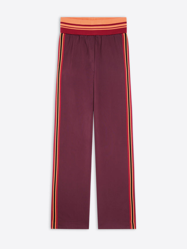 A pair of wide-leg pants in maroon, featuring double vertical stripes in yellow and orange running down the sides, with a matching red and orange striped elastic waistband.