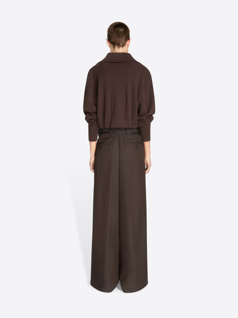Back view of a model standing against a light gray background wearing a dark brown long-sleeve collared cardigan and matching wide-leg trousers with a thin waist belt.