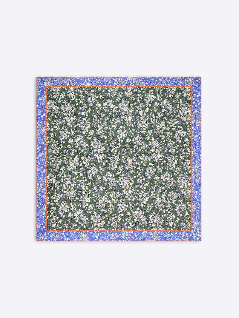 A square scarf featuring a dark green background with a dense white and light blue floral pattern, framed by a lilac border with small yellow accents on a light gray background.