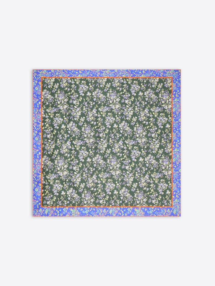 A square scarf featuring a dark green background with a dense white and light blue floral pattern, framed by a lilac border with small yellow accents on a light gray background.