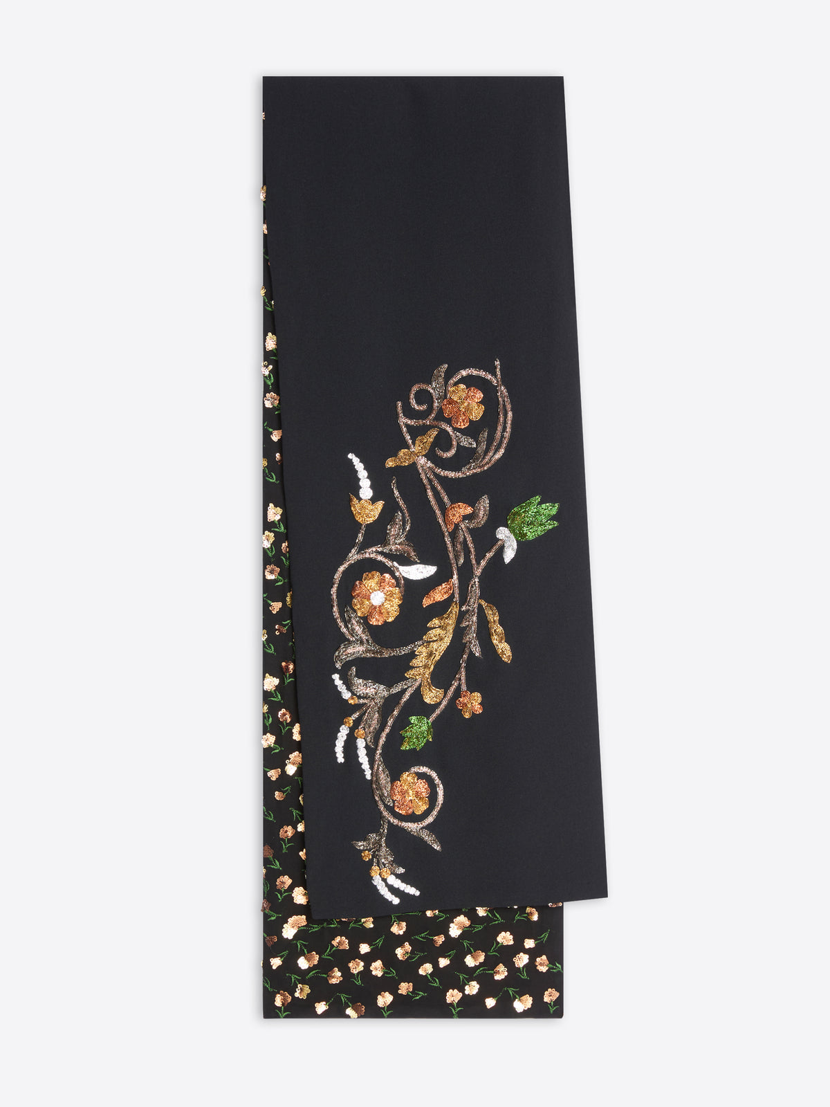 A black top featuring an ornate gold floral vine pattern on one side and a black base with small gold and white floral dots on the reverse, shown against a light gray background.