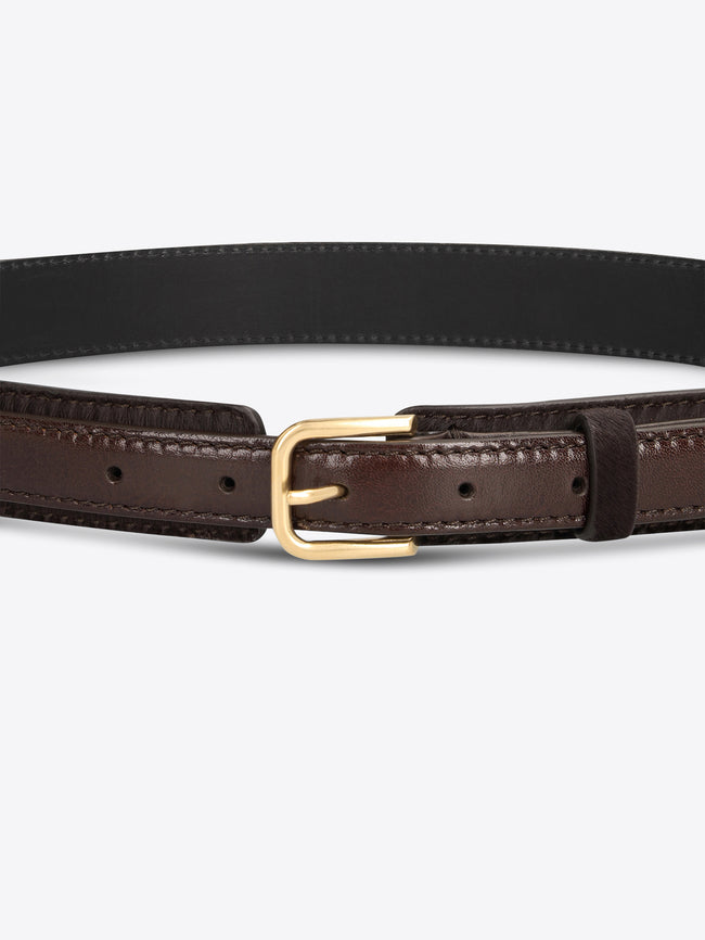 Close-up of a dark brown textured belt with smooth leather trim and a gold-toned buckle on a light gray background.
